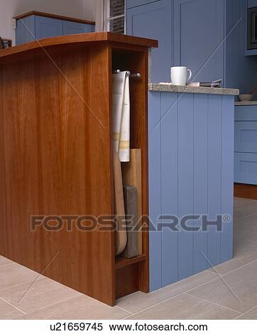 Stock Photography - Close-up of fitted cherrywood storage unit with storage for trays and tea-towels. Fotosearch