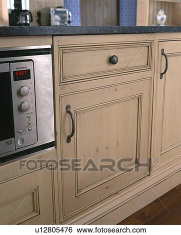 Stock Photograph - Close-up of fitted kitchen cupboard concealing refrigerator. Fotosearch