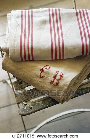 Stock Photography - Close-up of folded bolts of old red striped linen with monogrammed natural linen fabric. Fotosearch