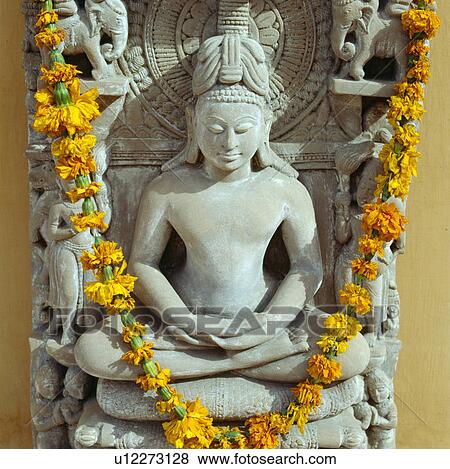 Stock Photo - Close-up of garland of marigolds on Rajastani statue. Fotosearch