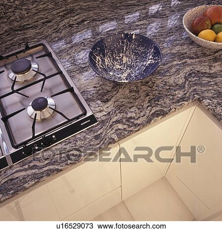 Stock Image - Close-up of gas hob in fitted unit with granite worktop. Fotosearch