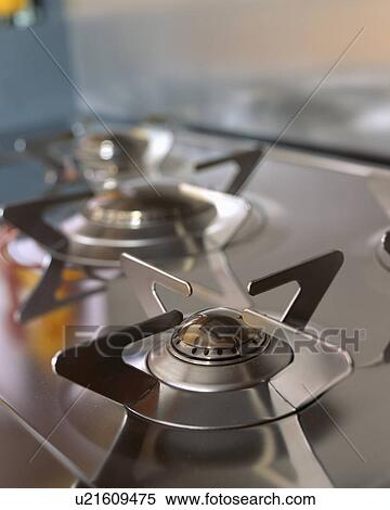 Stock Photography - Close-up of gas jets on stainless steel hob. Fotosearch
