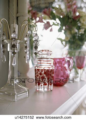 Stock Image - Close-up of glass candlesticks with antique cranberry glass jug . Fotosearch