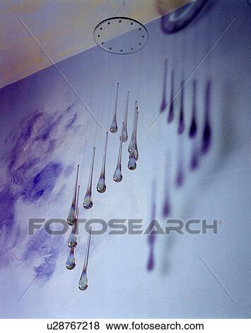 Stock Photo - Close-up of glass mobile against blue wall. Fotosearch