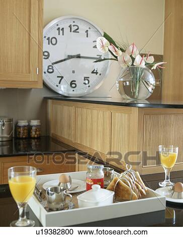 Close-up of glasses of orange juice and breakfast tray on worktop below large circular clock View Large Photo Image Stock Image - Close-up of glasses of orange juice and breakfast tray on worktop below large circular clock. Fotosearch