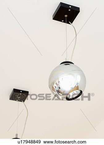 Stock Photo - Close-up of globe-shaped stainless-steel ceiling light. Fotosearch
