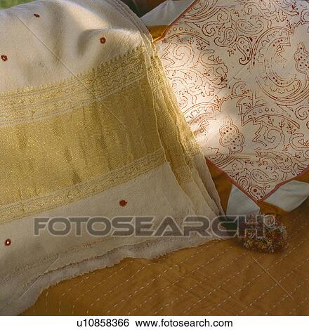 Stock Photograph - Close-up of gold-embroidered cashmere shawl and embroidered cushion. Fotosearch