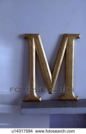 Picture - Close-up of gold letter M. Fotosearch