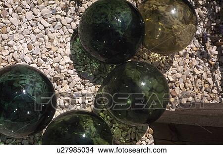 Picture - Close-up of green glass balls on gravel . Fotosearch