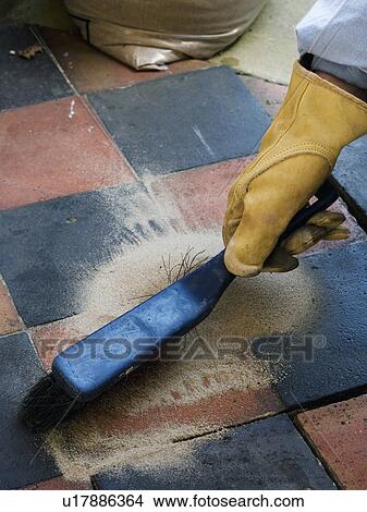 Close-up of hand wearing rubber glove brushing old terracotta paving tiles View Large Photo Image Picture - Close-up of hand wearing rubber glove brushing old terracotta paving tiles. Fotosearch