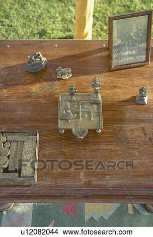 Close-up of Indian brass ornaments and black+white photgraph on wooden table View Large Photo Image Picture - Close-up of Indian brass ornaments and black+white photgraph on wooden table. Fotosearch