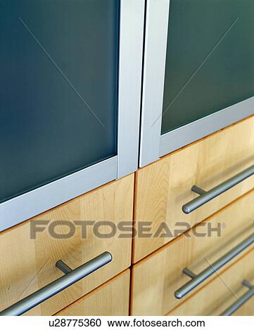 Stock Image - Close-up of kitchen cupboard doors with steel handles. Fotosearch