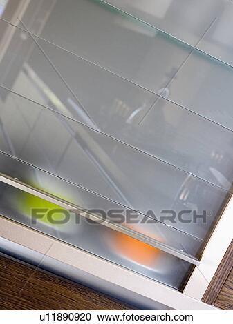 Stock Image - Close-up of kitchen cupboard with opaque glazed door. Fotosearch