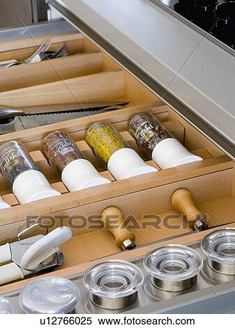Stock Photography - Close-up of kitchen drawer with small glass storage jars. Fotosearch