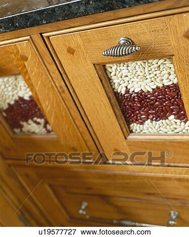 Stock Photo - Close-up of kitchen storage drawer with glass panel showing dried beans. Fotosearch