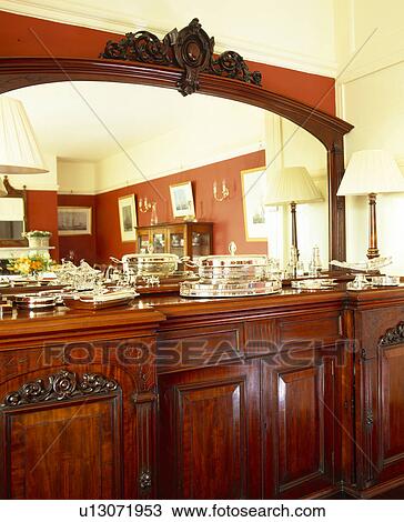 Close-up of large mirror above mahogany sideboard with collection of silver View Large Photo Image Stock Image - Close-up of large mirror above mahogany sideboard with collection of silver. Fotosearch
