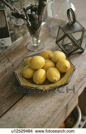 Picture - Close-up of lemons in ceramic bowl on wooden table. Fotosearch