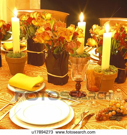 Close-up of lighted candles in terracotta flowerpots on table with white plates and small flower arrangements View Large Photo Image Stock Image - Close-up of lighted candles in terracotta flowerpots on table with white plates and small flower arrangements. Fotosearch