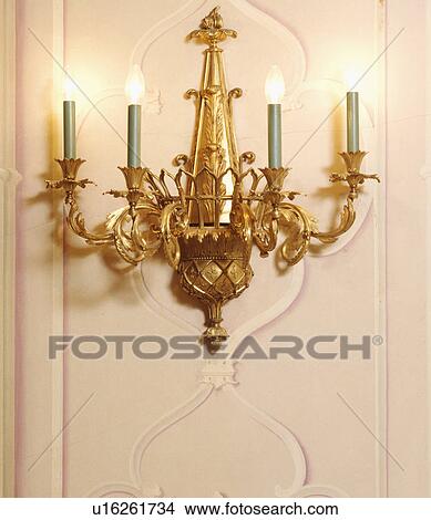 Close-up of lighted ornate brass wall-light View Large Photo Image Picture - Close-up of lighted ornate brass wall-light. Fotosearch