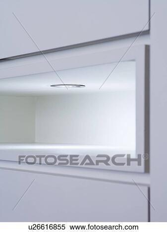 Stock Photography - Close-up of lighting above recess in kitchen cupboard. Fotosearch