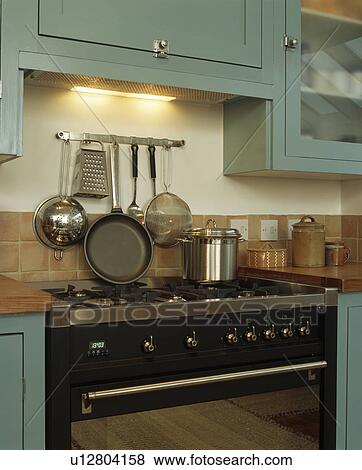 Close Up Of Metal Pans And Colander On Rack Above Range Oven Stock