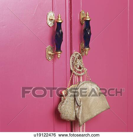 Stock Photograph - Close-up of metallic silver bags on fuchsia pink cupboard. Fotosearch