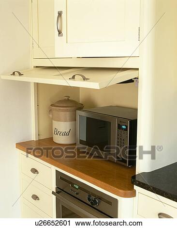 Close-up of microwave in cream kitchen storage cupboard with lift-up door View Large Photo Image Stock Image - Close-up of microwave in cream kitchen storage cupboard with lift-up door. Fotosearch