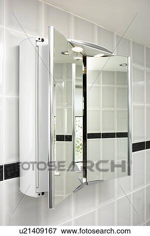 Stock Photo - Close-up of mirrored bathroom cabinet with doors open. Fotosearch