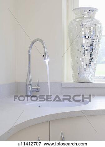 Close-up of mixer tap pouring water into underset basin in corner vanity unit View Large Photo Image Stock Photo - Close-up of mixer tap pouring water into underset basin in corner vanity unit. Fotosearch