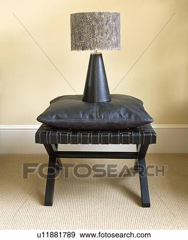Close-up of modern lamp and black cushion on black stool View Large Photo Image Stock Photo - Close-up of modern lamp and black cushion on black stool. Fotosearch