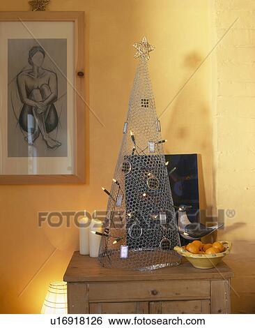 Stock Photograph - Close-up of modern metal Christmas tree in yellow living room. Fotosearch