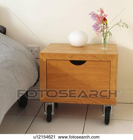 Close-up of modern pale wood bedside cabinet on casters View Large Photo Image Stock Image - Close-up of modern pale wood bedside cabinet on casters. Fotosearch