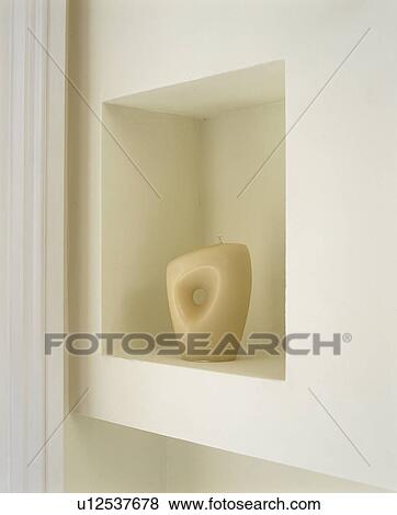 Stock Photo - Close up of modern sculptural candle in alcove. Fotosearch