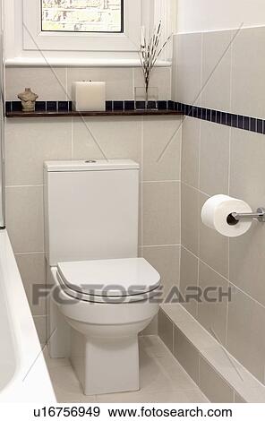 Stock Photo - Close-up of modern whtie toilet in tiled bathroom. Fotosearch