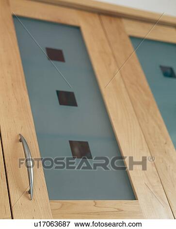 Stock Photo - Close-up of opaque glass panel in pale wood cupboard door. Fotosearch