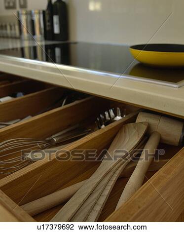 Stock Image - Close-up of open drawer with cutlery and wooden utensils. Fotosearch