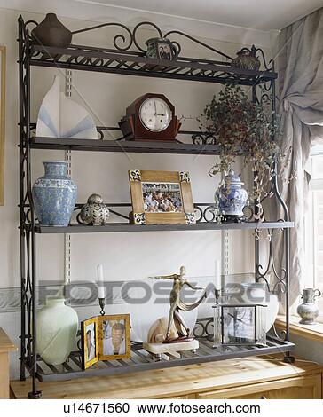 Close-up of ornamental metal shelves with clock and pictures View Large Photo Image Stock Image - Close-up of ornamental metal shelves with clock and pictures. Fotosearch