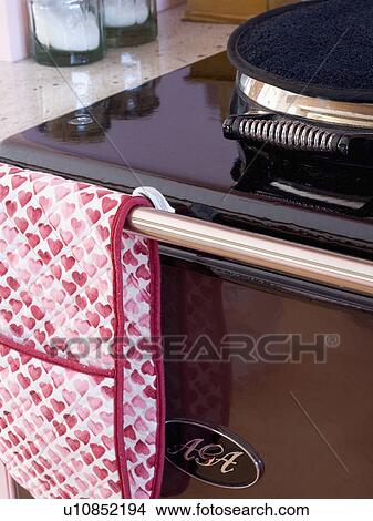 Picture - Close-up of oven-mitt on black Aga oven. Fotosearch