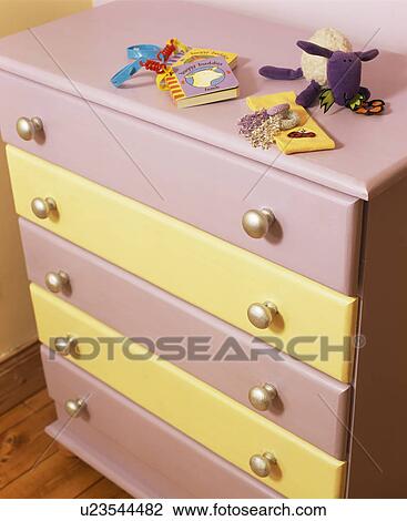 Stock Image - Close-up of painted mauve and cream chest-of-drawers. Fotosearch