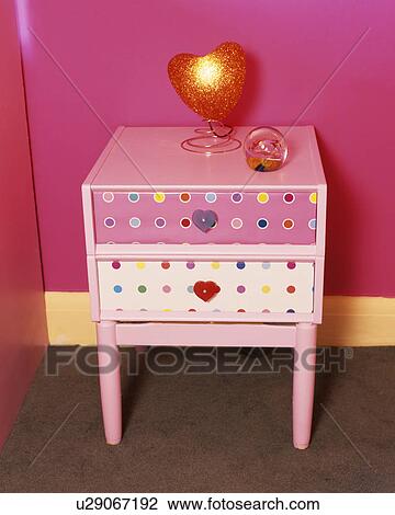 Stock Image - Close-up of painted pink chest-of-drawers in child's pink bedroom. Fotosearch