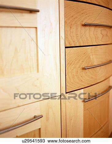 Stock Image - Close-up of pale wood modern fitted kitchen cupboard. Fotosearch