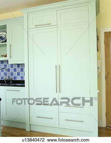 Close-up of pastel green storage unit concealing fridge freezer View Large Photo Image Stock Image - Close-up of pastel green storage unit concealing fridge freezer. Fotosearch