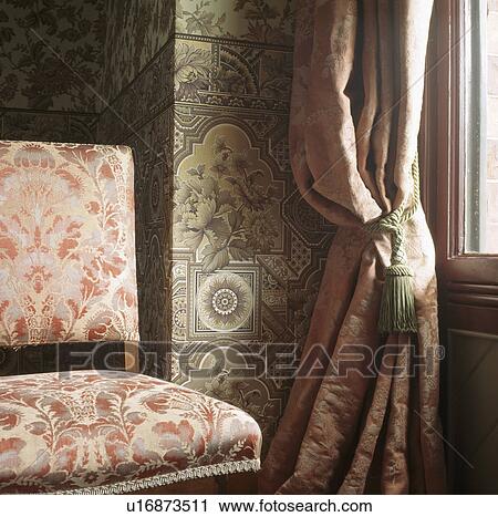 Close Up Of Patterned Red Damask Curtains And Upholstered Chair