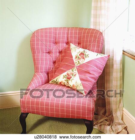 Close-up of pink patchwork cushion on pink checked armchair in corner of pale green living room View Large Photo Image Stock Photo - Close-up of pink patchwork cushion on pink checked armchair in corner of pale green living room. Fotosearch