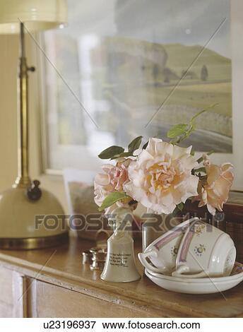 Close up of pink roses and antique cups and saucers on pine cupboard View Large Photo Image Stock Photo - Close up of pink roses and antique cups and saucers on pine cupboard. Fotosearch