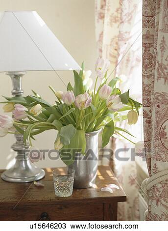 Close-up of pink tulips in metal vase with white lamp View Large Photo Image Stock Image - Close-up of pink tulips in metal vase with white lamp. Fotosearch
