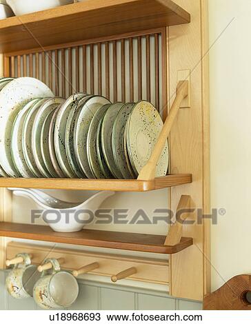 Stock Image - Close-up of plates on wooden plate rack. Fotosearch