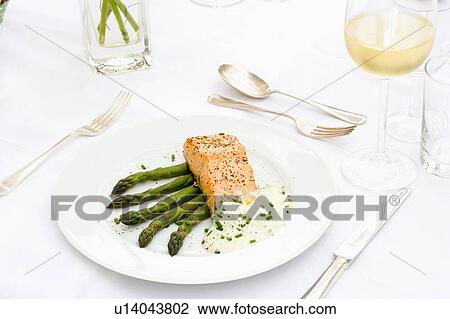 Close-up of poached salmon with asparagus on white plate with silvery cutlery and glass of white wine View Large Photo Image Stock Image - Close-up of poached salmon with asparagus on white plate with silvery cutlery and glass of white wine. Fotosearch