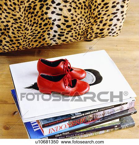Stock Image - Close-up of red leather tap-shoes on pile of books. Fotosearch