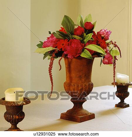 Close-up of red rhododendrons and gerberas in red stone vase on table with candles in small urns View Large Photo Image Stock Photography - Close-up of red rhododendrons and gerberas in red stone vase on table with candles in small urns. Fotosearch